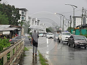 Outdoor scenery during raining season with traffic jam at apartment road.