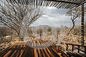 Outdoor seating area of a private hut in Waterberg Guest Farm, Namibia. Beer on table with chairs for relaxation