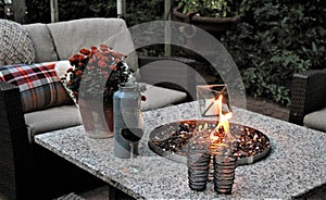 Outdoor seating arrangement around a gas fire pit table in the fall