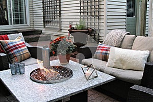 Outdoor seating arrangement around a gas fire pit table in the fall