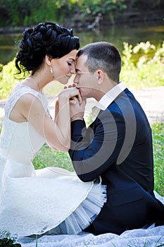 Outdoor sensual portrait of young beautiful couple in love posing in summer park boyfriend kissing his girlfriend