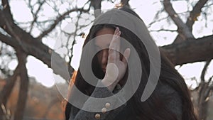 Outdoor sensual portrait of young beautiful stylish woman with long dark hair and lips posing on autumm street