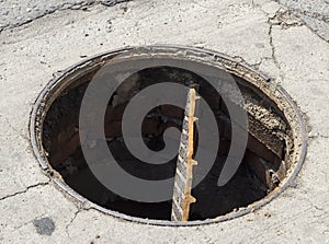 Outdoor sewer hatch, close up, broken and open sewer cover