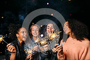 Outdoor shot of laughing friends with sparklers photo