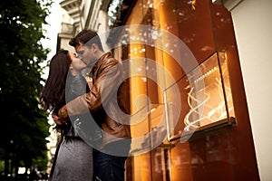 Outdoor shot of passionate lovely couple embrace and kiss each other, have good relationships, walk across calm city