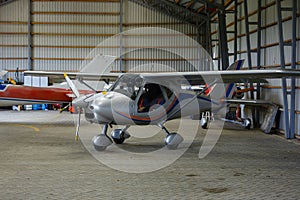 Outdoor shot of small plane standing in shed