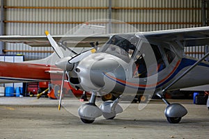 Outdoor shot of small plane standing in shed