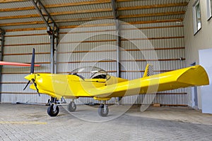 Outdoor shot of small plane standing in shed