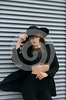 Stylish girl with red lips wears black bra and hat