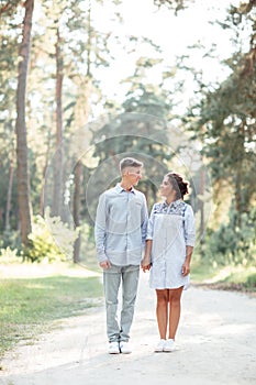 Outdoor shot of young happy couple in love on sunny day on nature. Man and woman hugging, sunlight in summer park. valentine`s da