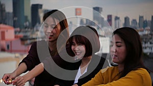 Outdoor shot of young people at rooftop party. Happy group of asia girl friends enjoy and play sparkler at roof top party.