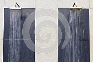 Outdoor shower head with flowing water at swimming pool
