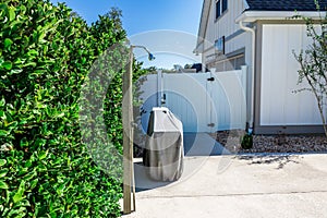 An outdoor shower near a backyard fenced swimming pool