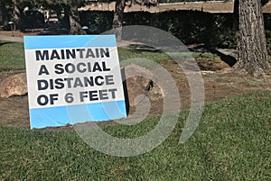 Outdoor sign stating Maintain a social distance of 6 feet