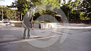 Outdoor skatepark for extreme sports .Young athlete ride on roller blades. Skater boy in black casual clothes makes