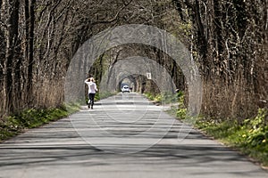 Outdoor sporting activity running through atmospheric avenue of trees on dutch the coutryside