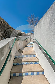 Outdoor stairs with blue tile risers and wall-mounted green handrails at San Antonio, Texas