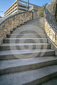 Outdoor stairway with stone half wall and railings in San Antonio River Walk