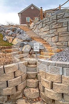 Outdoor steps made of stone that leads to homes on a hill with retaining walls