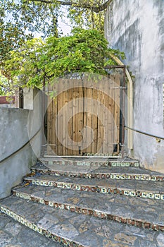 Outdoor stone stairway leading to a wooden gate of a building