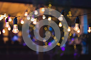 Outdoor string lights hanging on a line in backyard.