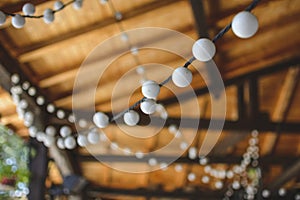 outdoor string lights hanging on a line with under a wooden roof.