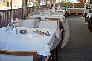 Outdoor summer cafe interior with tables with a white tablecloth