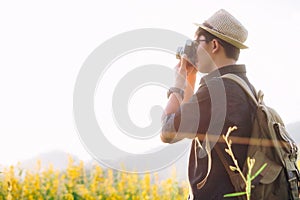 Outdoor summer lifestyle young man relax with camera travel photo of photographer Making pictures in hipster style glasses and ha