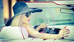 Esterno estate ritratto elegante bionda antico una donna gestione convertibile auto. alla moda attraente Fiera commerciale capelli 