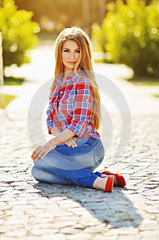 Outdoor summer portrait of young pretty cute blonde girl. Beautiful woman posing in spring.