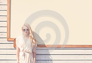 Outdoor summer sensual fashion portrait beautiful young blond woman of a white dress in sunglasses on the street on the background