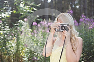 Outdoor summer smiling lifestyle portrait of pretty young blonde