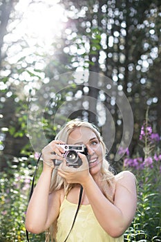 Outdoor summer smiling lifestyle portrait of pretty young blonde