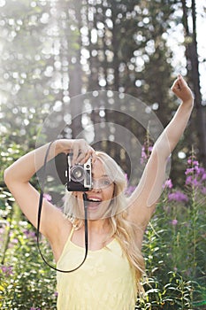 Outdoor summer smiling lifestyle portrait of pretty young blonde