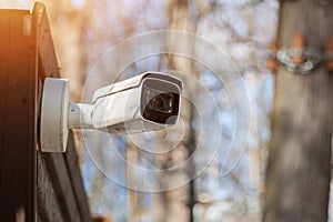 outdoor surveillance camera attached to wooden surface. CCTV security camera in forest park