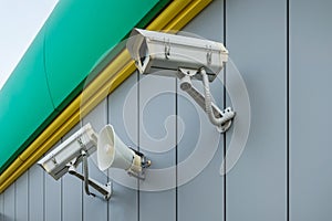 Outdoor surveillance and tracking security camera with a megaphone on the wall of building