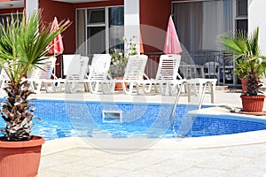 Outdoor swimming pool and loungers at resort sunny day