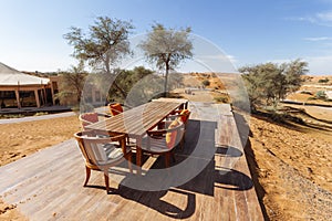 Outdoor table with chairs on the sand with trees and blue sky at Abu Dhabi, UAE