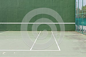 Outdoor tennis court and green knock board with white lines for personal practice