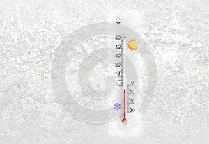 Outdoor thermometer on a frozen window shows minus 5 degrees celsius