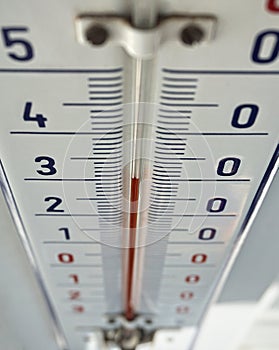 Outdoor thermometer with the retro design displaying high temperature of thirty degrees of Celsius