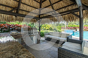 Outdoor tiki hut with outdoor grill kitchen and pool