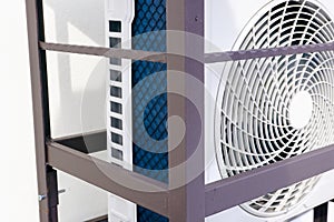 Outdoor unit of air heat pump, air conditioner. Radiator, fan. Closeup photo. Air heat pump beside house