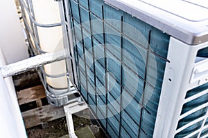 Outdoor unit of a low-power air heat pump located in front of the house.