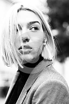 Outdoor urban female portrait, black and white. Fashion model. Young woman posing in Milan streets.