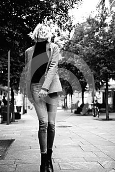 Outdoor urban female portrait, black and white. Fashion model. Young woman posing in Milan streets against.