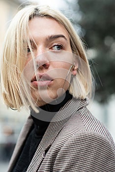 Outdoor urban female portrait. Fashion model. Young woman posing in Milan streets. Beautiful caucasian girl with blond hair