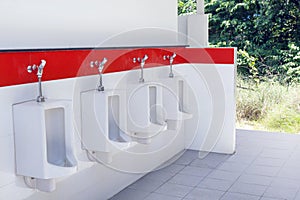 Outdoor urinal toilet old white and red color, the toilet of man with toilet view by urinals outdoors