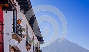 Outdoor view of balcony with some flowers in a pot of ancient building in the main street of Antigua city with agua