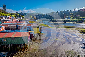 Outdoor view of beautiful coorful wooden houses on stilts palafitos, in a low tide day view in gorgeous sunny day in